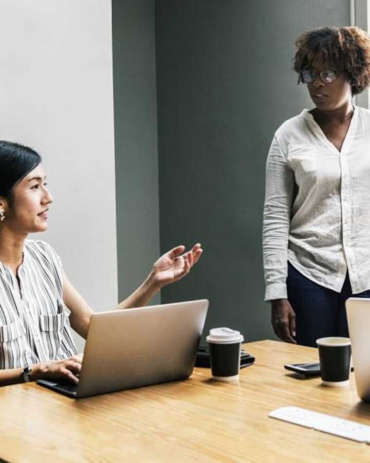 Office workers discussing auto-enrolment schemes in a meeting