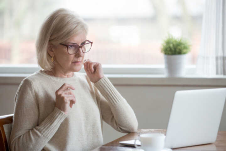 Older woman looking at her laptop screen with concern