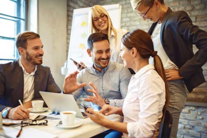 Group of happy young employees discussing a project