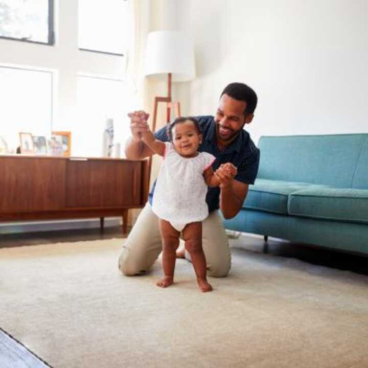 Dad playing with toddler in their home