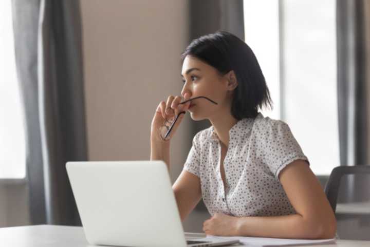 Anxious business woman looking away from her laptop