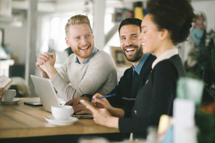 Three happy employees having a discussion