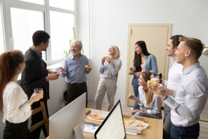 Diverse business team eating pizza together in the office