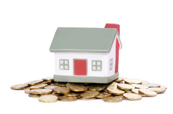 A toy house on top of a pile of coins