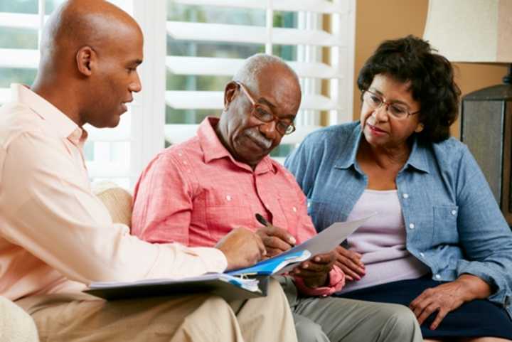 Couple talking to a financial adviser at home