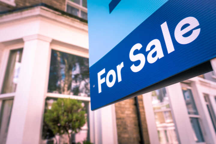 Estate agent For Sale sign outside terraced home