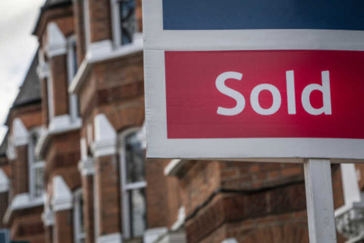 Estate agent 'Sold' sign on a residential street