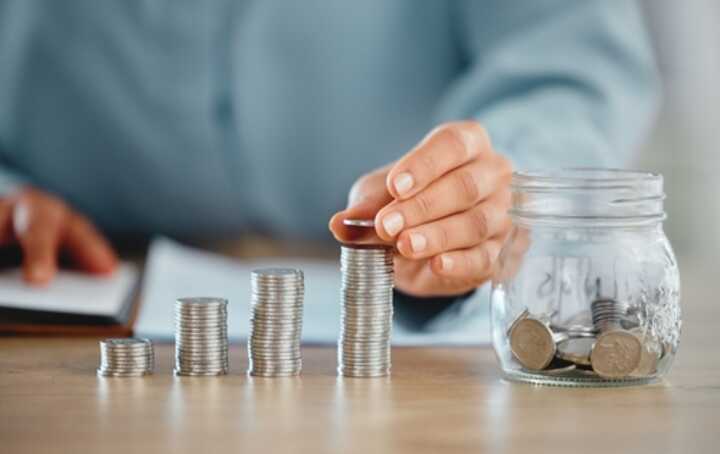 A woman building up piles of coins