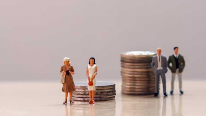 Model figures in front of two piles of coins, with the men's pile much taller