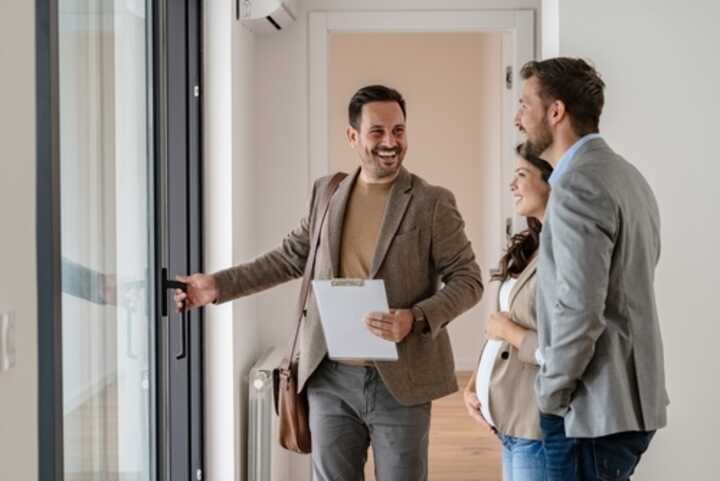 Young couple viewing an apartment for sale with an estate agent