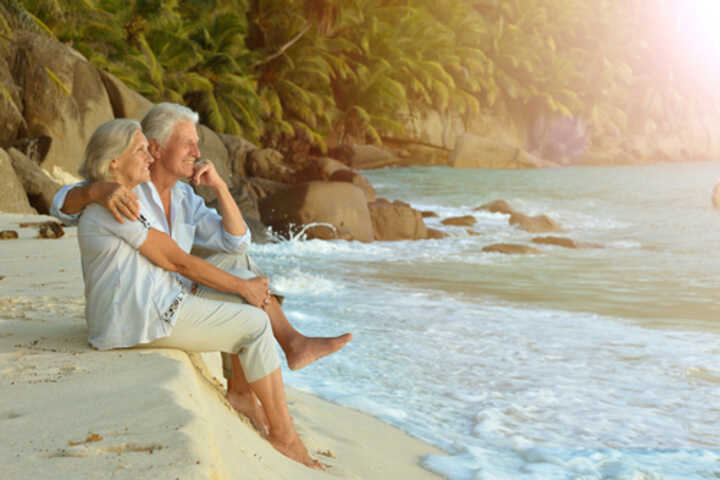 Older couple relaxing on a tropical beach