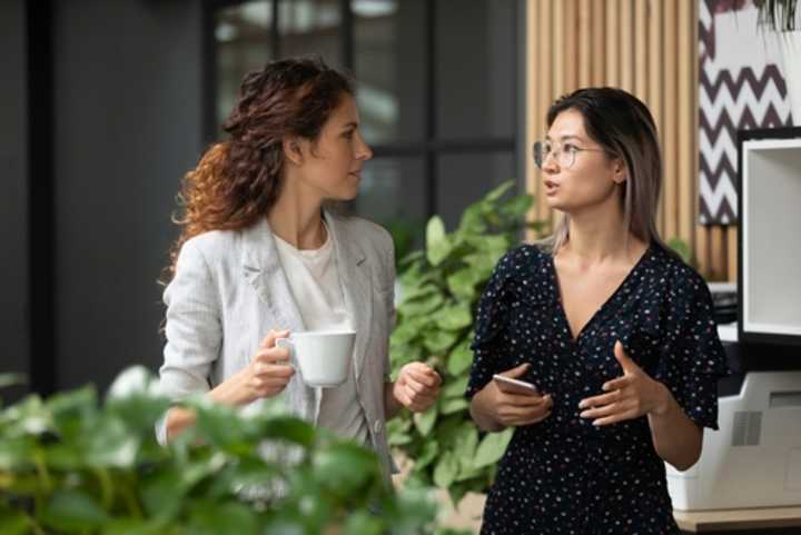 Two female colleagues having a discussion in the office