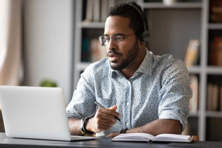 Young male employee working on a laptop in a home office