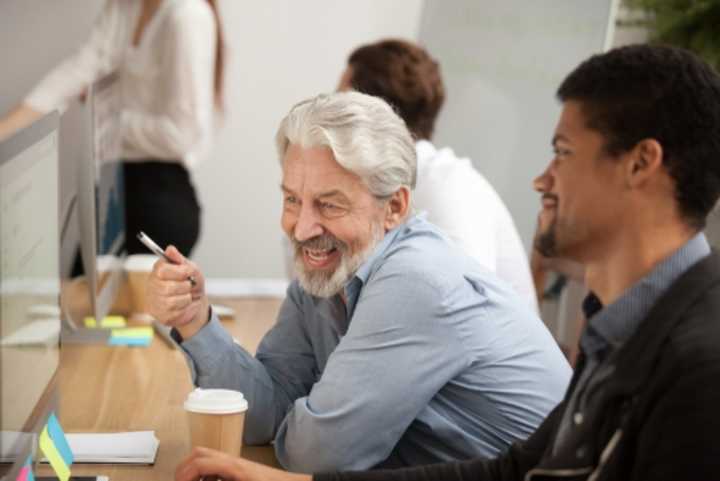 Older employee and younger colleague having a discussion in the office